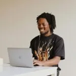 Atento Corporate: Vagas Híbridas man in black crew neck t-shirt using macbook