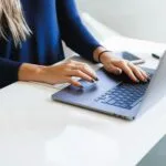 Auxiliar de Cobrança Remoto e mais woman in blue long sleeve shirt using macbook pro